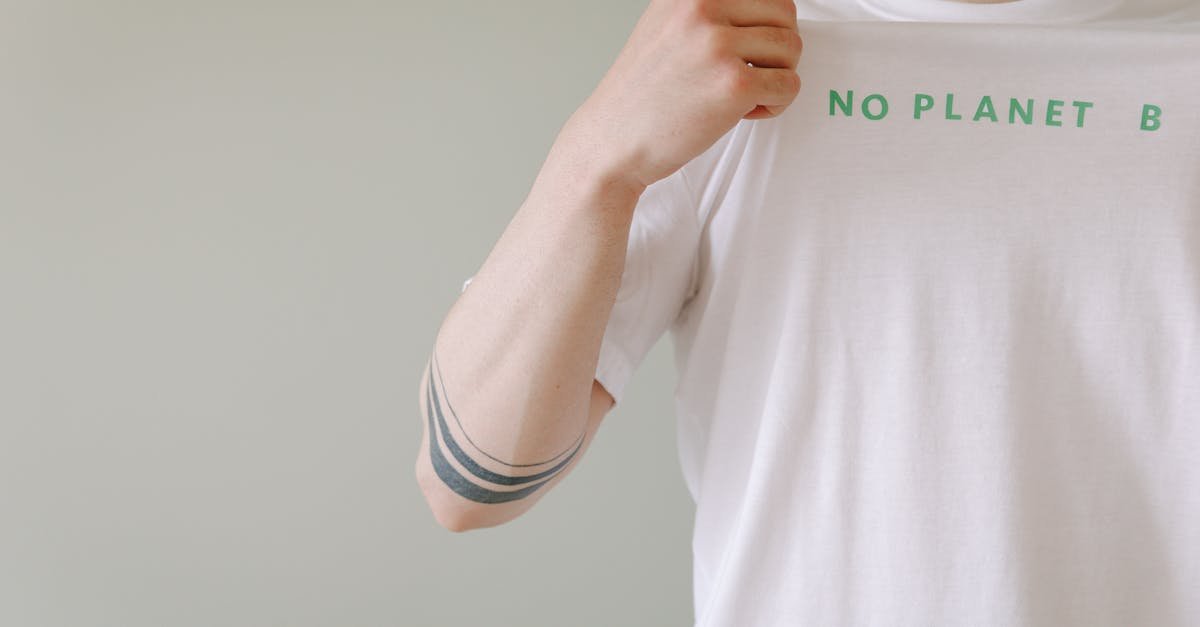 Close up of a person showcasing a t shirt with a no planet b environmental message